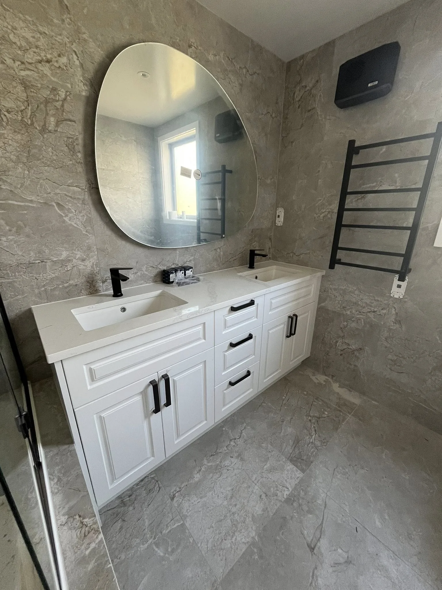 Modern bathroom vanity installation with stone tiles and matte black fixtures