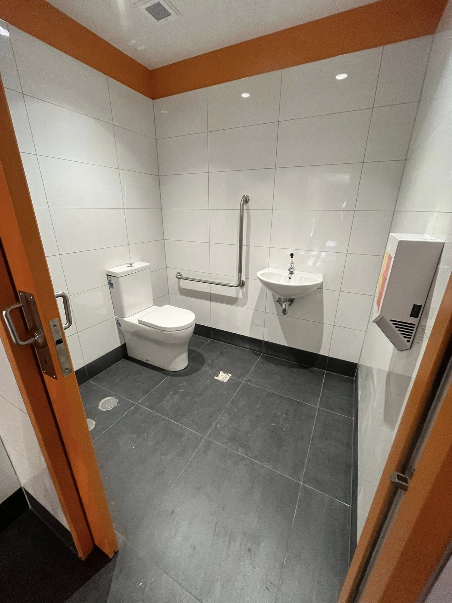 Commercial accessible bathroom fit-out with grab rails