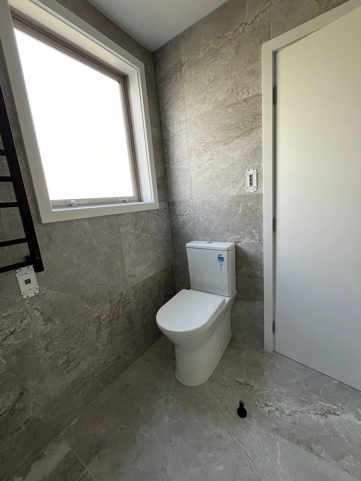 New toilet installation with natural stone tiling